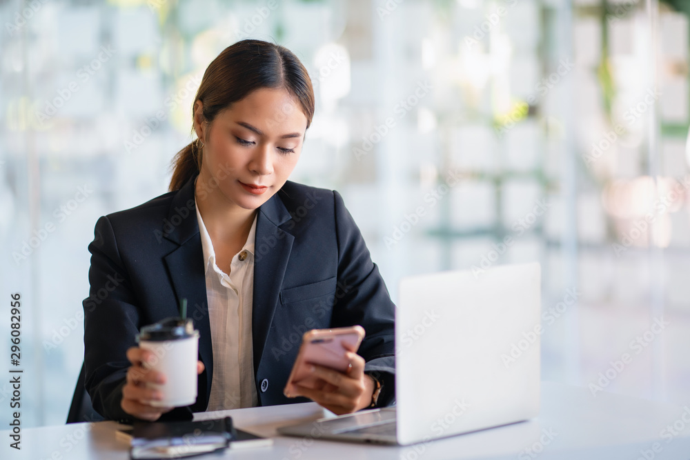 Young Asian female entrepreneur talking on the phone while working at home office. Young Asian female entrepreneur talking on the phone while working at home office.