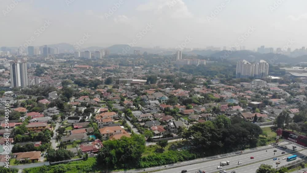Top Aerial View Of Large And Crowded Highways Between Parks Full Of Trees Near Housing - Tilt Up Top Aerial View Of Large And Crowded Highways Between Parks Full Of Trees Near Housing - Tilt Up