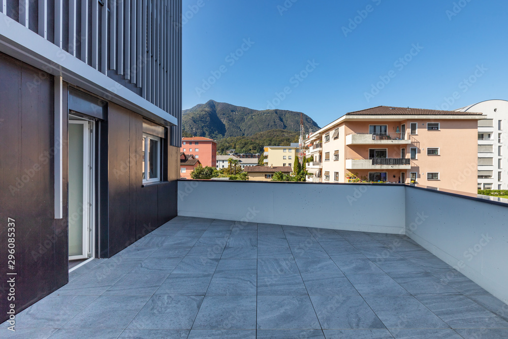 Large terrace with large marble tiles overlooking the Swiss hills in Ticino - obrazy, fototapety, plakaty 