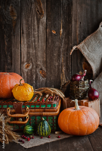 Happy Thanksgiving background  pumpkins and wicker basket on old wooden table.