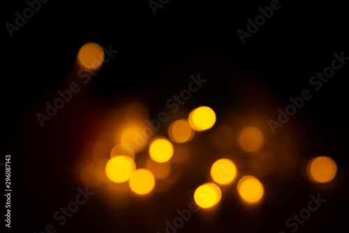 Out of focus yellow and warm lights on black background.