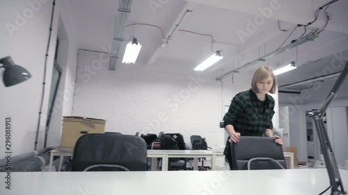 Woman checking cable and adjusting office chair