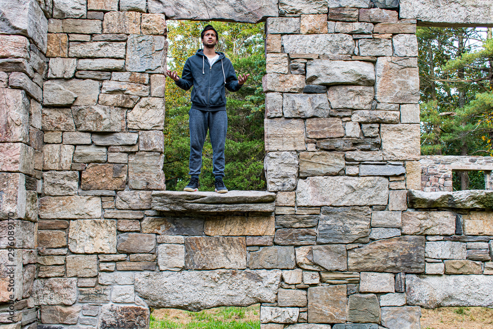 frustrated young man outside standing in window of abandoned building