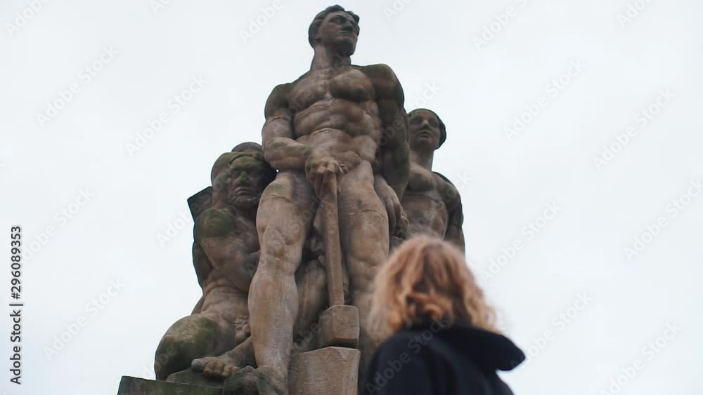 The guy looks at the sculpture on a rainy day The guy looks at the sculpture on a rainy day