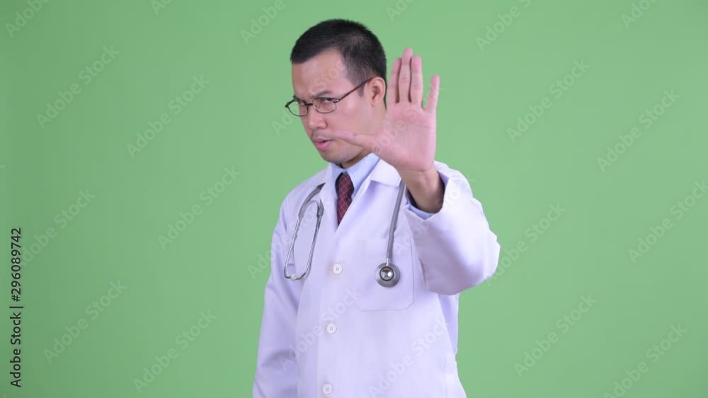 Stressed Asian man doctor with stop gesture