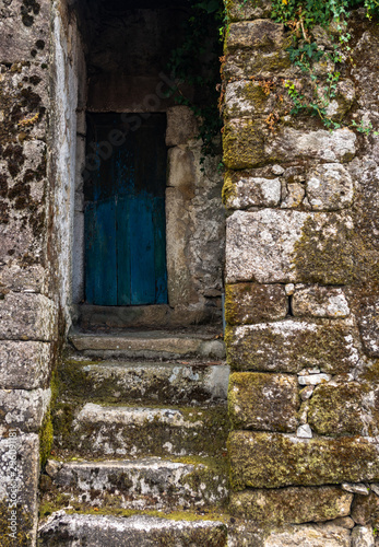 Blue old door on a small traditional granite house in north of portugal © paulogon1963