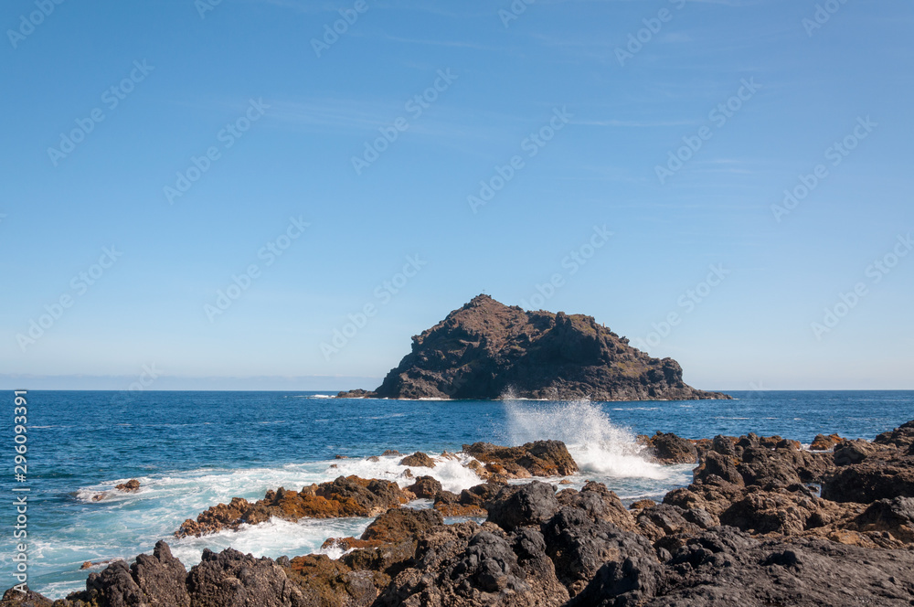 Natural monument Rock of Garachico, surrounding by blue sea and waves.