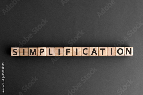 Simplification - word from wooden blocks with letters, Simplified simplification concept, top view on grey background