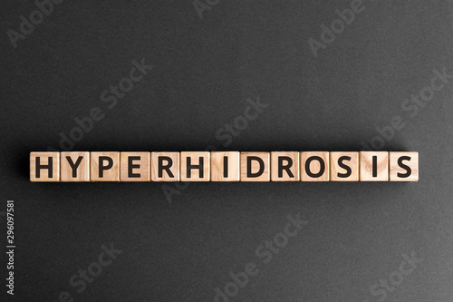 Hyperhidrosis - word from wooden blocks with letters, excessive sweating hyperhidrosis concept,  top view on grey background photo