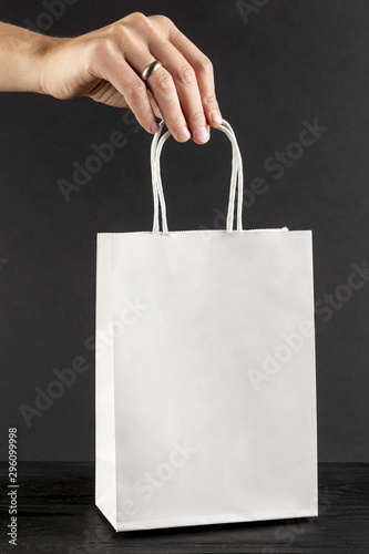 Hand holding a white paper bag