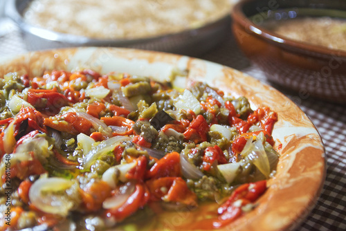 Typical Catalan escalibada dish with fresh vegetables in a rustic kitchen in Catalonia. Home made cuisine and gastronomy travel concept with empty copy space for Editor's text. photo