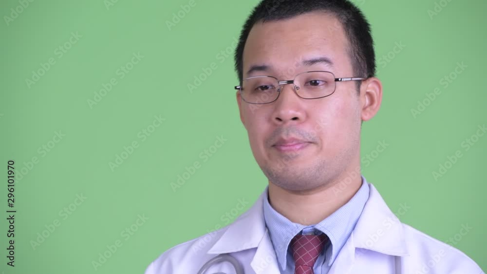 Closeup profile view of happy Asian man doctor with eyeglasses talking Closeup profile view of happy Asian man doctor with eyeglasses talking