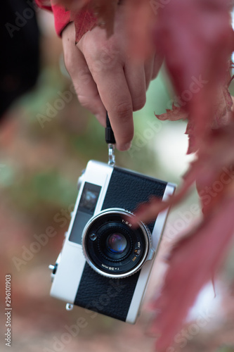 Close-up of a vintage camera hanging on the hand of a girl