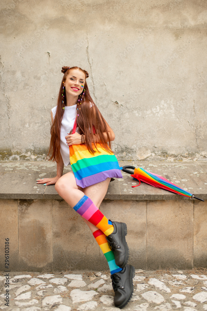 Fashionable lgbt girl in colorful socks wearing male boots. Stylish lesbian  with lgbt rainbow on her face posing outdoor Stock Photo | Adobe Stock