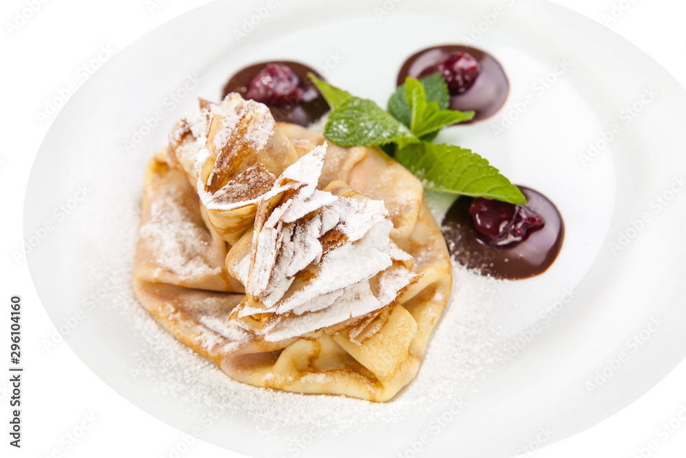 Delicious pancake with cherry and chocolate on plate isolated on White Background. Fresh Homemade Crepes with mint Delicious pancake with cherry and chocolate on plate isolated on White Background. Fresh Homemade Crepes with mint