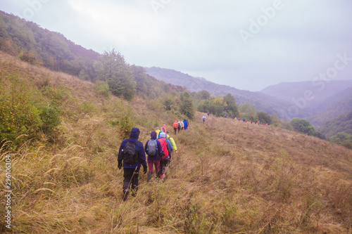 Rearview of unrecognizable people hiking on a rainy day in nature