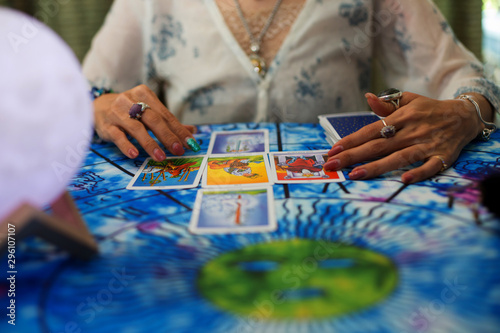 The fortune teller is using cards and crystal glass balls to see the fortune on the horoscope table.