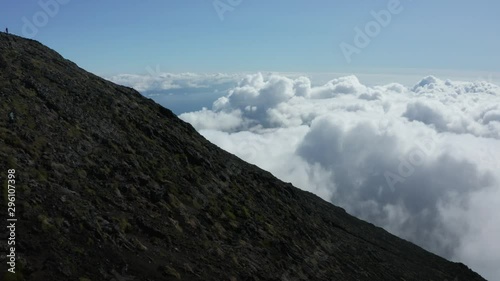 Drone aerial view of the steep slope of Pico Mountain above the clouds. Highest peak of Portugal in Azores photo