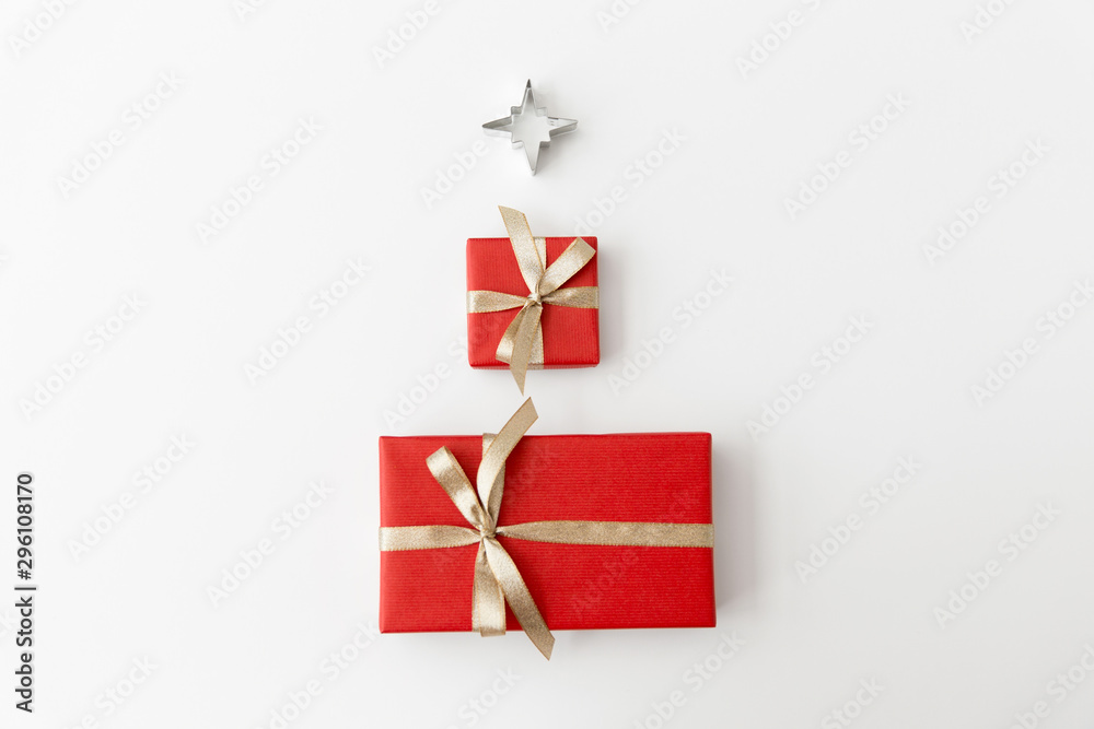 winter holidays, new year and celebration concept - red gift boxes and kitchen mold in shape of star on white background winter holidays, new year and celebration concept - red gift boxes and kitchen mold in shape of star on white background