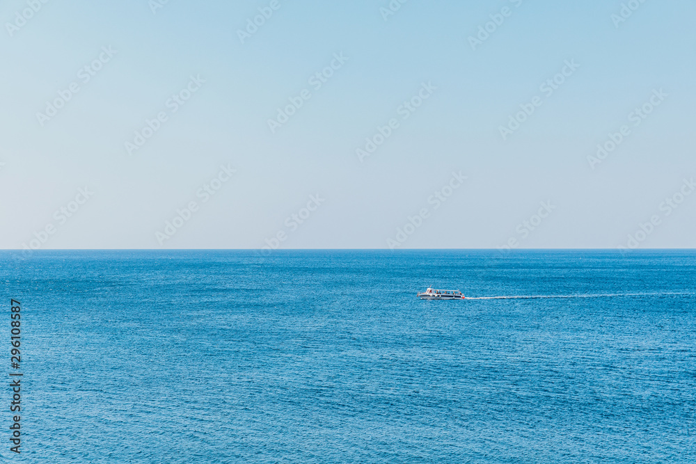 Boat on blue sea surface aerial view. Nature background