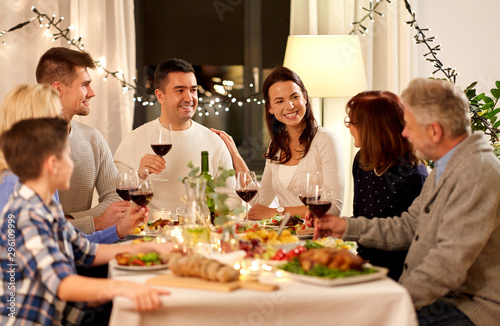 celebration  holidays and people concept - happy family having dinner party  drinking red wine and toasting at home