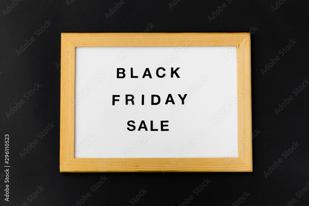 shopping and marketing concept - white magnetic board with black friday sale words