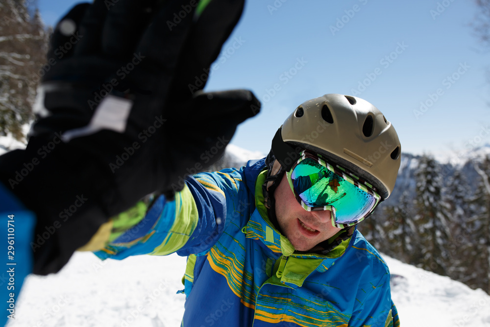 Portrait of sporty man in helmet and mask doing handshake at mountain resort. Portrait of sporty man in helmet and mask doing handshake at mountain resort.