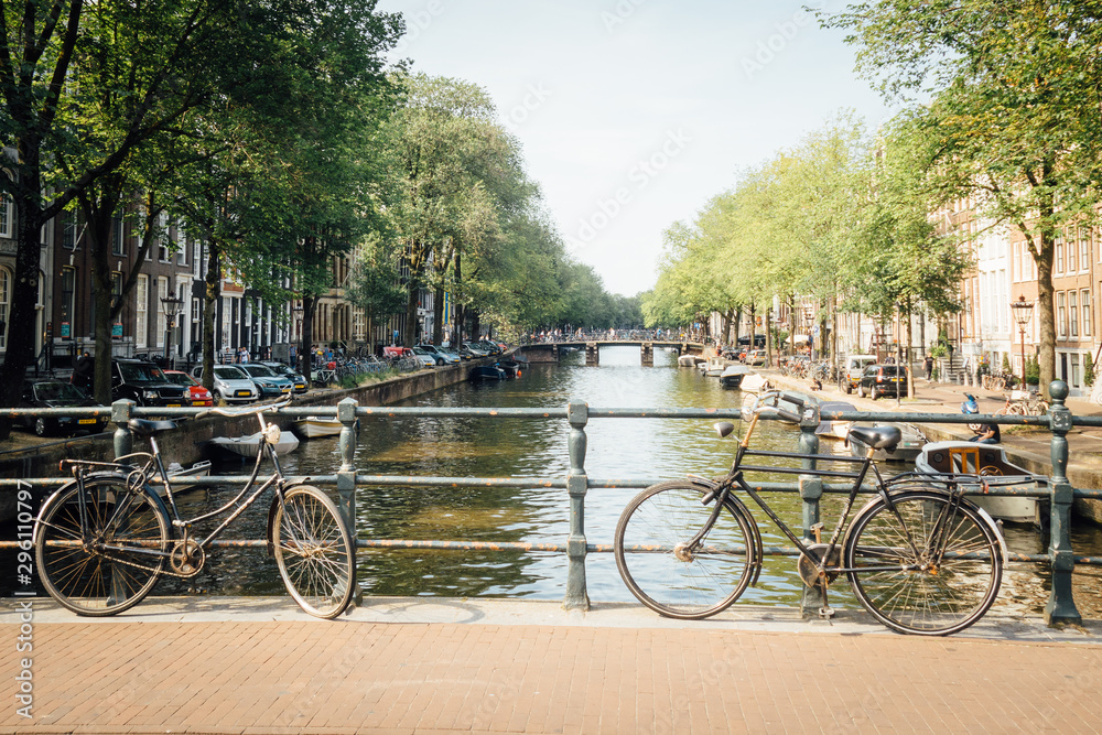 des vélos à Amsterdam posés sur une rampe de pont devant un canal