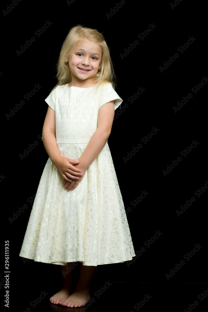 Naklejka premium Portrait of a cute little girl on a black background. Happy chil