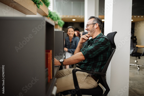 Handsome stylish entrepreneur interacting and working in modern coworking office workspace photo