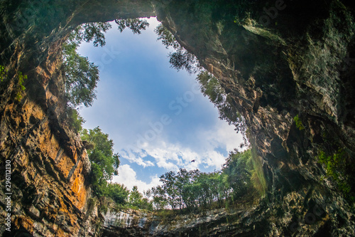 Melissani cave or Melissani lake in Kefalonia Greece. View of the hole of the cave s roof surrounded by trees