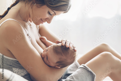 Картината върху платно Loving mom breastfeeding her newborn baby at home