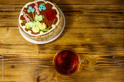 Fototapeta Naklejka Na Ścianę i Meble -  Cup of tea and Kiev cake on a wooden table. Top view