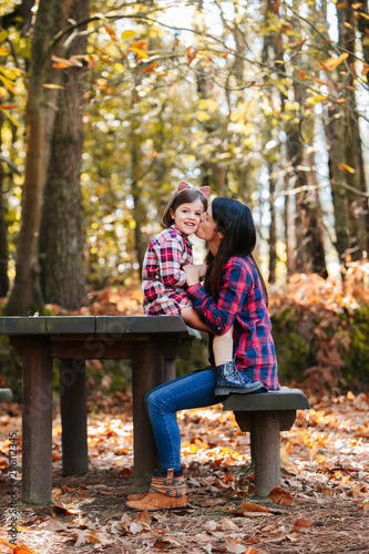 Mother with daughter at park in autumn