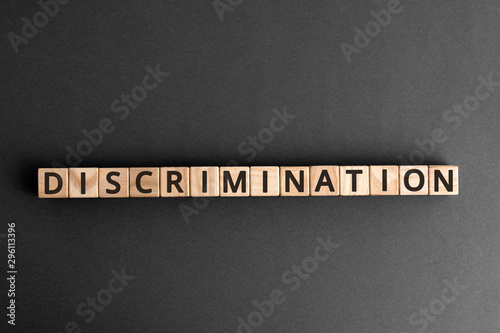Discrimination - word from wooden blocks with letters, Human rights. Prejudice and inequality. Racism. Sex discrimination concept, top view on grey background