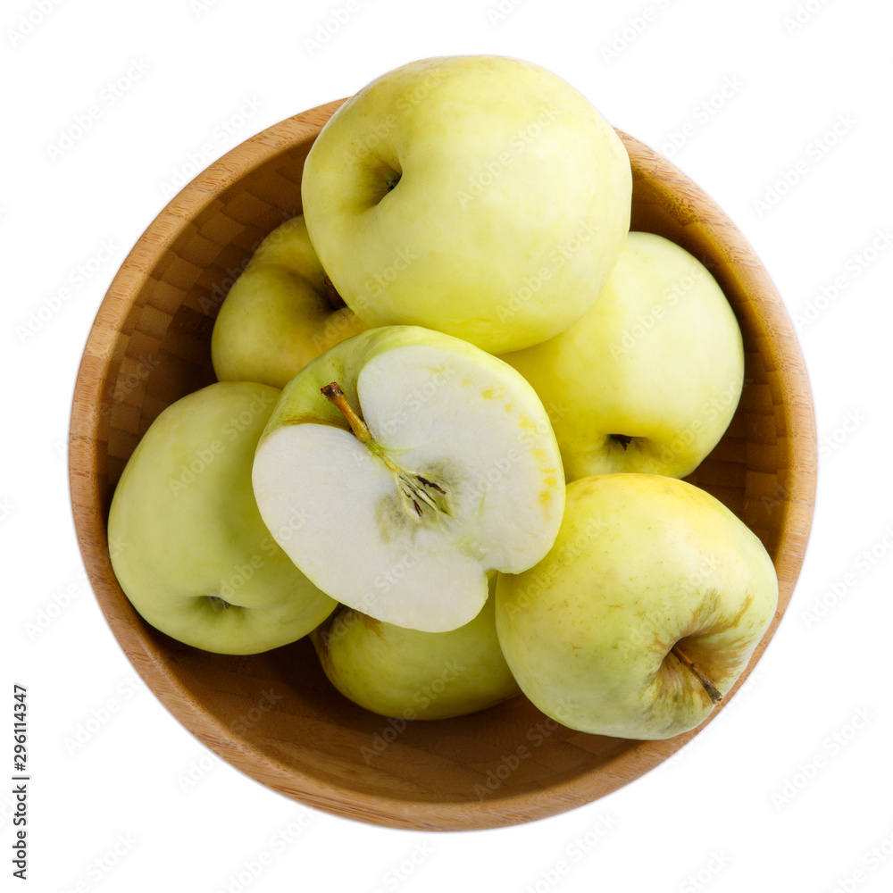 Ripe yellow apples in wooden bowl isolated on white background. Antonovka apples. Top view, close-up. Ripe yellow apples in wooden bowl isolated on white background. Antonovka apples. Top view, close-up.