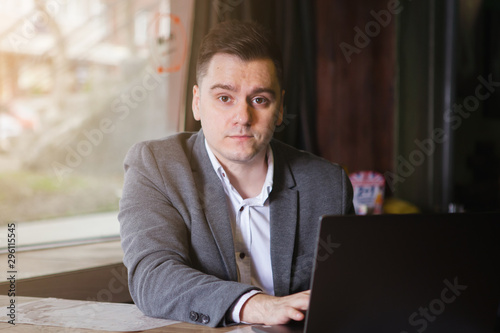 Young successful businessman is sitting at a table in a bar.