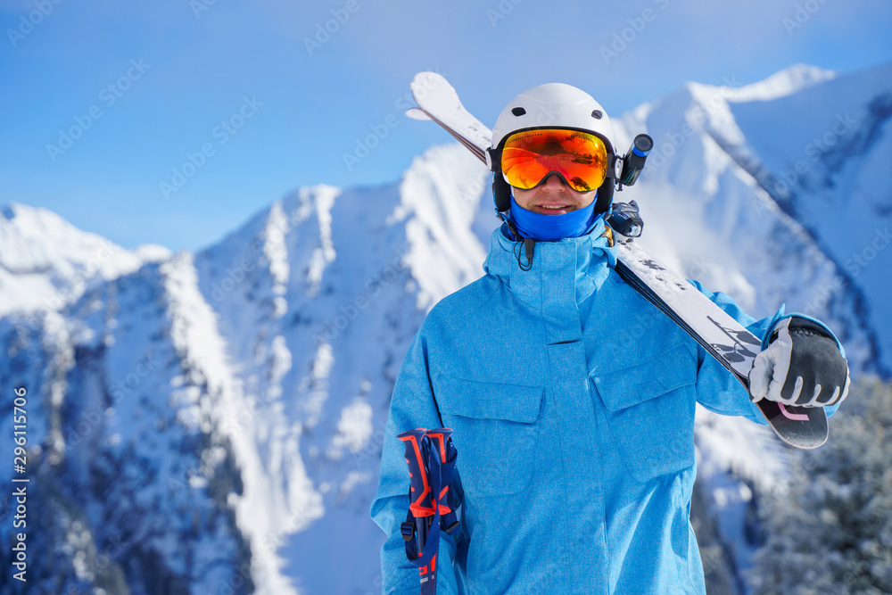 Portrait of man in helmet with skis on snowy resortю