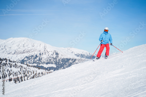Athletic men in helmet skiing on snowy slope.