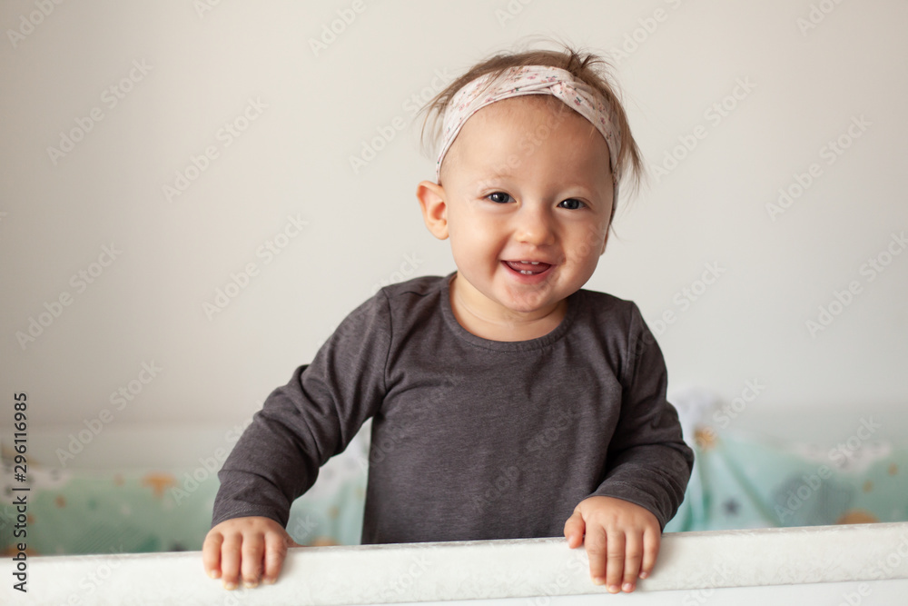 Cute baby laughing, standing in crib. Happy baby. Baby emotions. Baby smile. Cute baby laughing, standing in crib. Happy baby. Baby emotions. Baby smile.
