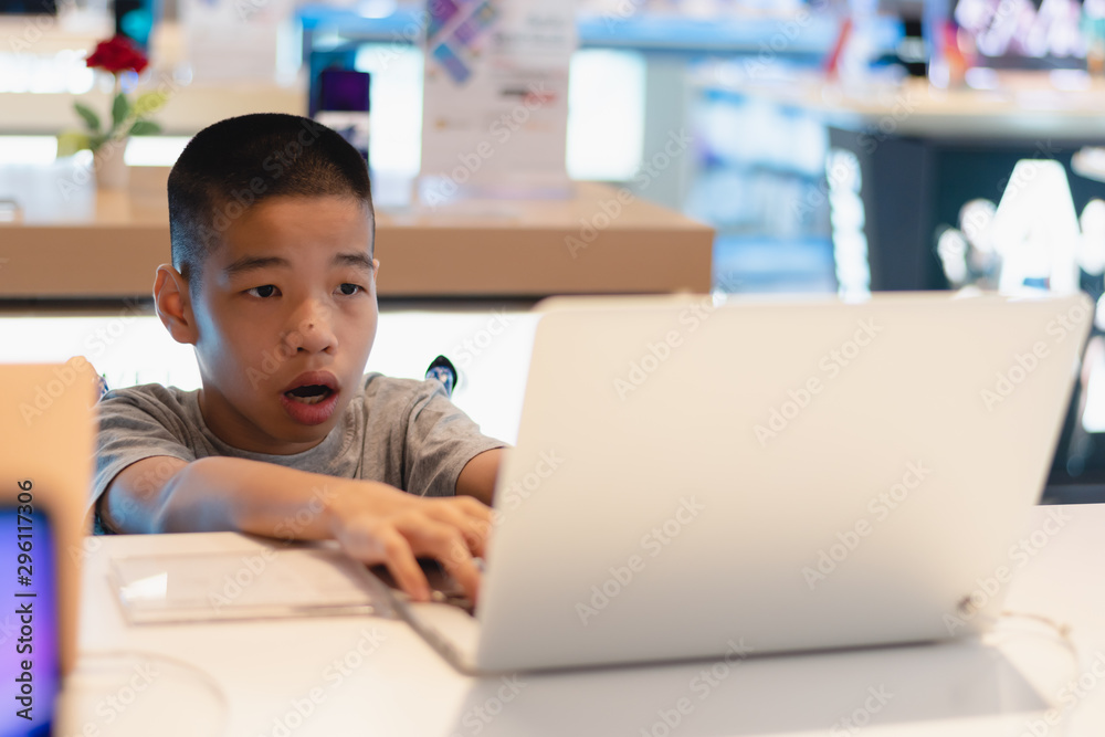 Disabled child on wheelchair trying to use a computer with excitement in an IT shop , Special children's lifestyle, Life in the education age of special need kids, Happy disability kid concept. Disabled child on wheelchair trying to use a computer with excitement in an IT shop , Special children's lifestyle, Life in the education age of special need kids, Happy disability kid concept.