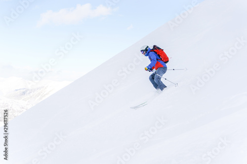 Side photo of athlete man with backpack skiing