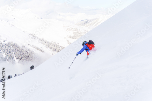 Photo from back of sportsman with backpack skiing