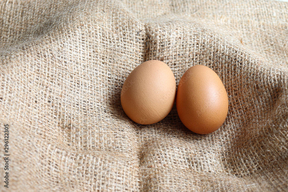 Heap Organic brown two Eggs of chicken uncooked freshness nutrition healthy on brown sack for background texture soft focus close up Heap Organic brown two Eggs of chicken uncooked freshness nutrition healthy on brown sack for background texture soft focus close up