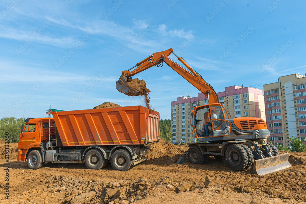 The modern excavator performs excavation work on the construction site. The modern excavator performs excavation work on the construction site.