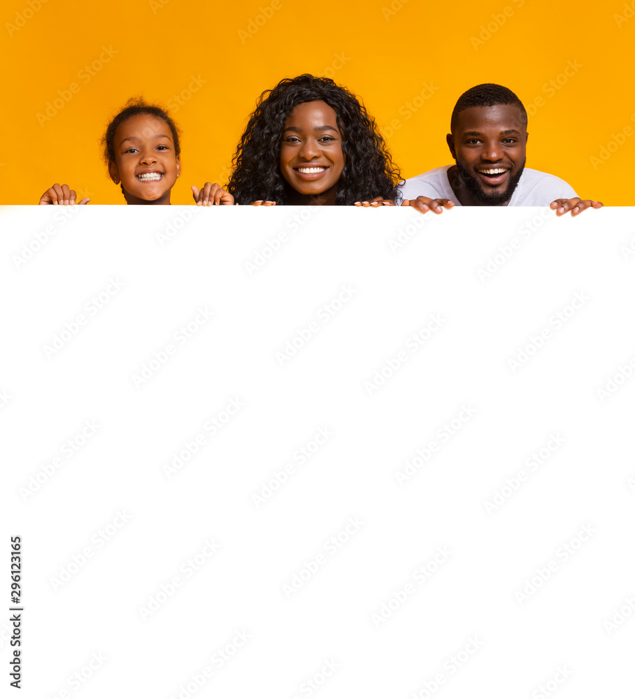 Black family leaning on blank white board for advertisement Black family leaning on blank white board for advertisement