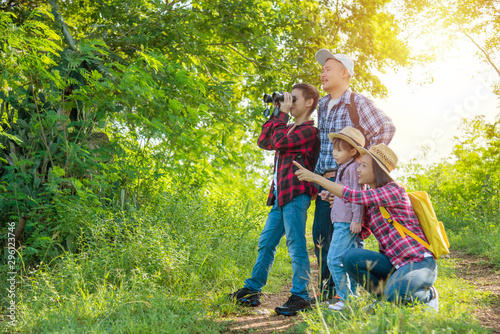 Happy asian family trekking in forest together on vacation.
