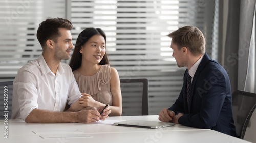Confident manager realtor banker consulting happy diverse young couple