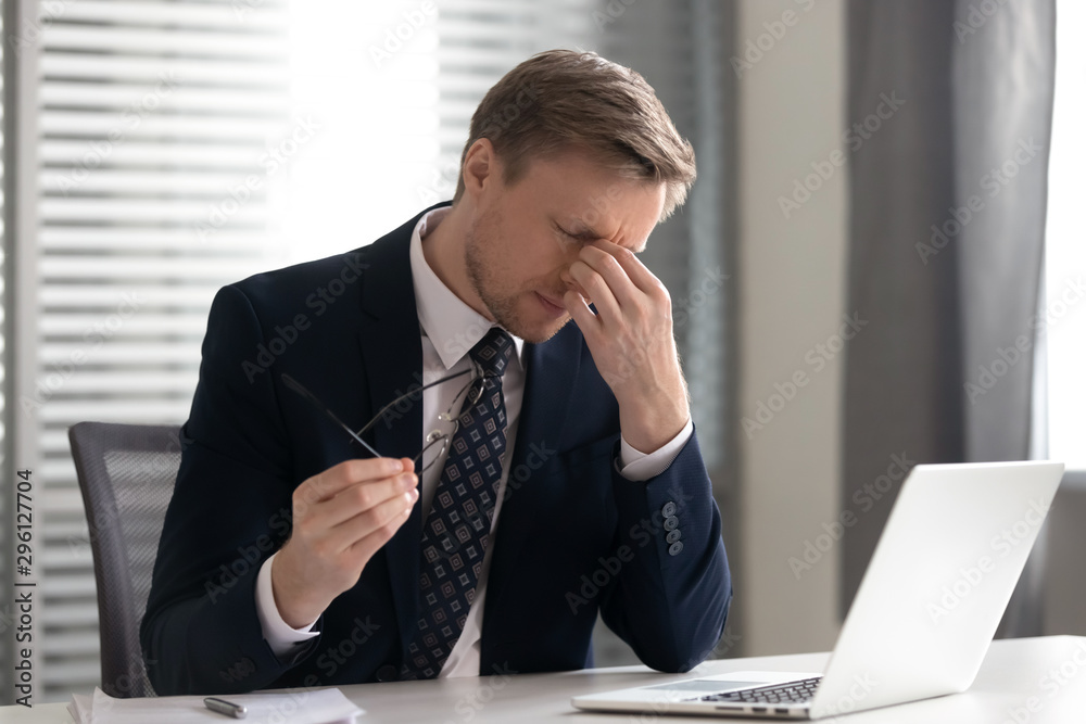 Businessman taking off glasses, suffering from dry eyes syndrome Businessman taking off glasses, suffering from dry eyes syndrome