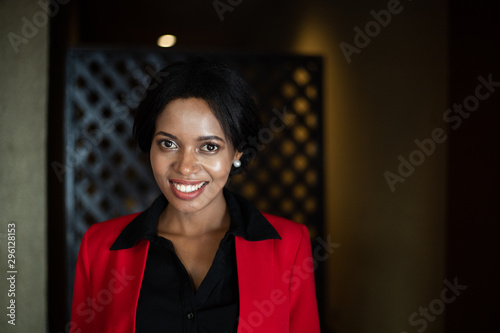 Portrait of smiling young black woman on red suite